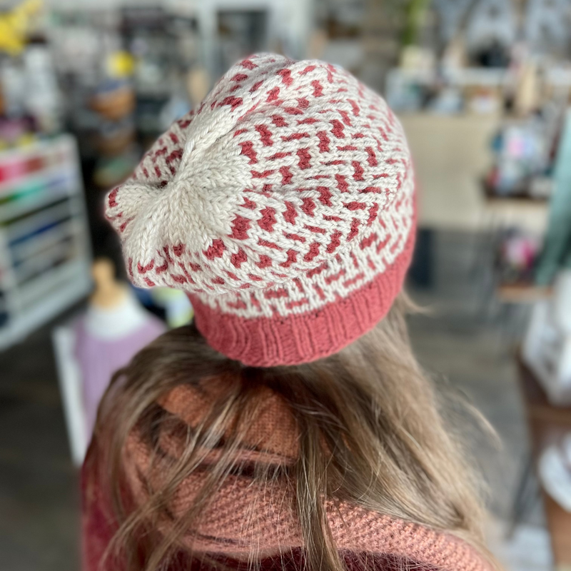 Person wearing a red and white knit Tinture hat by Andrea Mowry